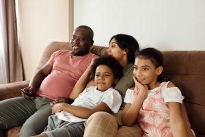 Photo of a family: Dad, mom, boy, and girl, on a couch